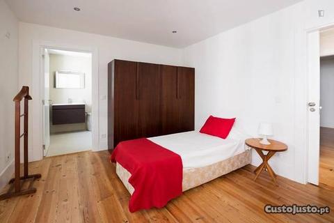 Quarto com cama de solteiro, com casa de banho